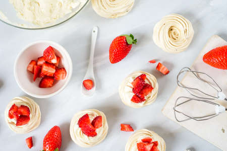 Strawberry pavlova cake nests, meringue decoration on a culinary tableの写真素材