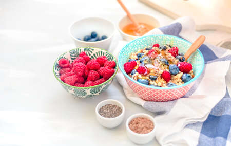 High protein healthy breakfast, buckwheat porridge with blueberries, raspberries, flax seeds and honey Closeup view, selective focusの写真素材
