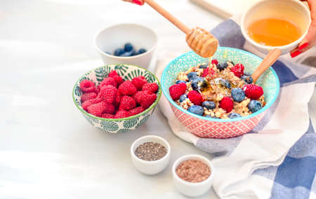 High protein healthy breakfast, buckwheat porridge with blueberries, raspberries, flax seeds and honey Closeup viewの写真素材