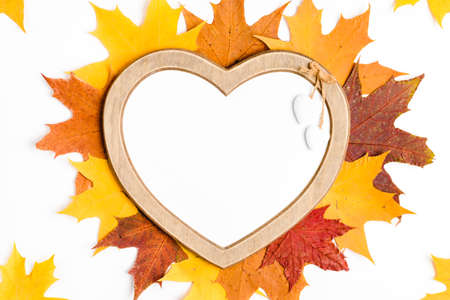 Autumn composition, maple leaves, heart shaped frame, top view, flat lay
