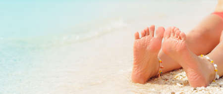Women's sexy legs on the beach. Beach travel concept.
