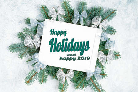 Happy Holidays Text with Holiday Evergreen Branches and Berries in Corner Over Rustic Woodenの写真素材