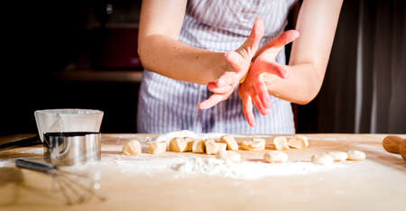 rolling out dough on kitchen table, close upの写真素材