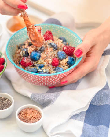 High protein healthy breakfast, buckwheat porridge with blueberries, raspberries, flax seeds and...
