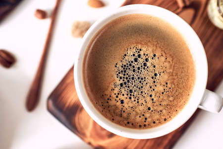 Cappuccino or latte with frothy foam,  coffee cup top view closeup isolated on whiteの写真素材