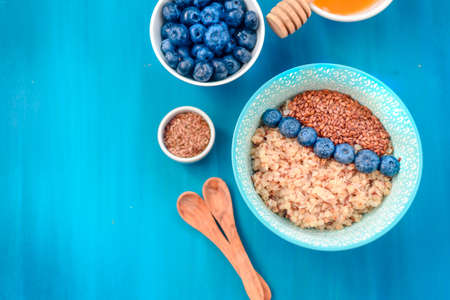 Buckwheat porridge in a bowl with flax seeds and blueberries.の写真素材