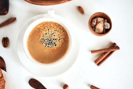 Cappuccino or latte with frothy foam, blue coffee cup top view closeup isolated on white