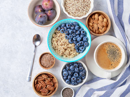 Healthy breakfast of superfoods, quinoa, honey, nuts figs coffeeの写真素材