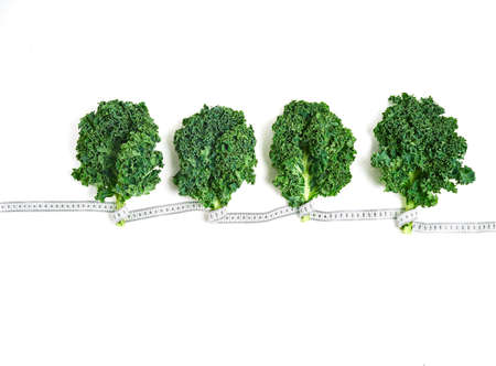 kale wrapped in measuring tape, concept diet, slimming, healthy eating top view