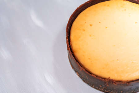 whole, freshly baked cheesecake on neutral backgroundの写真素材