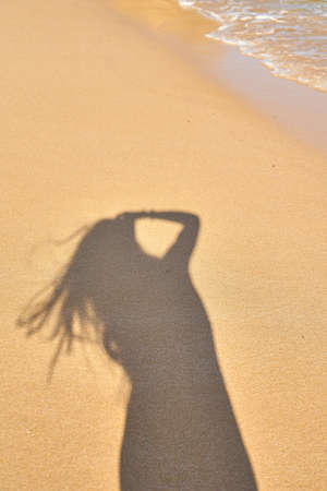 shadow from the photographer girl in the sand, silhouette in the sand, waveの写真素材