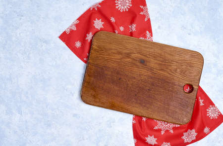 Empty kitchen cutting board with red christmas tablecloth.の写真素材