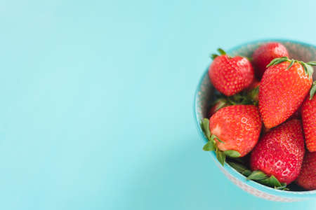 strawberries in a colorful bowl on colorful backgroundの写真素材