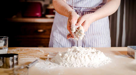 The concept of making bread, baking. Woman kneads the dough. Kneading the doughの写真素材
