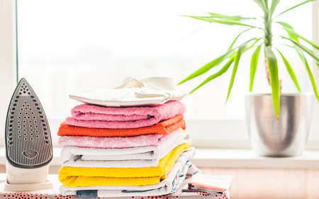 ironed items and iron on the ironing boardの写真素材