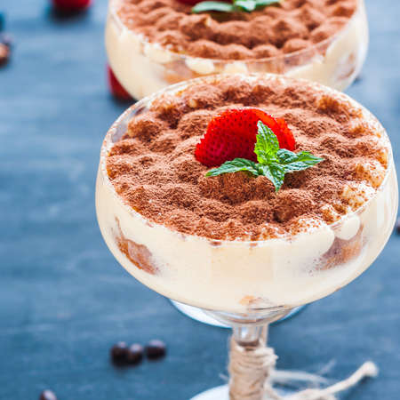 Tiramisu dessert in a cocktail glass decorated with cocoa on the woodenの写真素材