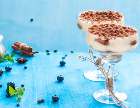 Luxury tiramisu dessert in a cocktail glass decorated with cocoa on the woodenの写真素材