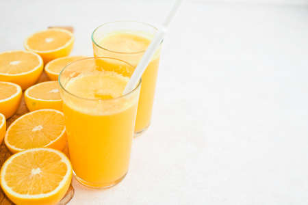 Orange juice in glass with mint, fresh fruits on wooden backgroundの写真素材