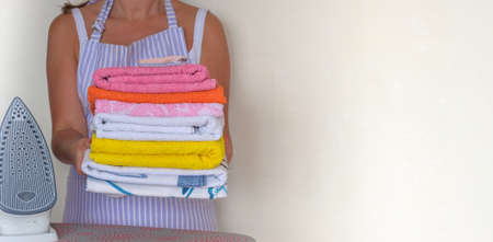 Happy young beautiful woman ironing clothes. Houseworkの写真素材