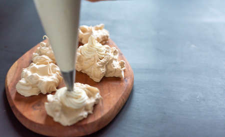 the process of creating Pavlova dessert, decorating the meringue with creamの写真素材