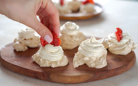 decorating the meringue with strawberriesの写真素材