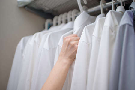 white men's shirts on the shoulders in the closetの写真素材