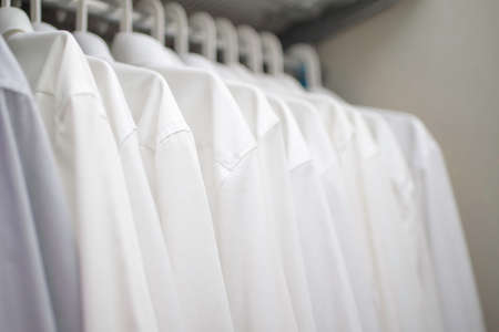 white men's shirts on the shoulders in the closetの写真素材