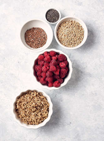 oatmeal with raspberries chia seeds and honey on a white tableの写真素材