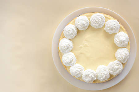 classic cheesecake on a white plate, decorated with cream, top viewの写真素材