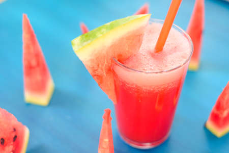 Glass of watermelon smoothie on a wooden blue table. Selective focusの写真素材