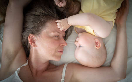 mother and baby lie on bed top view, motherhood concept, mothers day