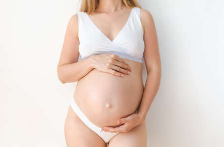 studio shot of a pregnant belly on a white backgroundの写真素材