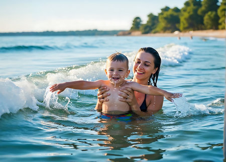 Mother and son playing in the sea. Happy family having fun on the beach.の素材