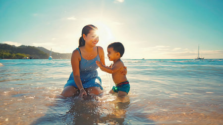 Mother and son playing in the sea at the day time. Concept of friendly family.の素材