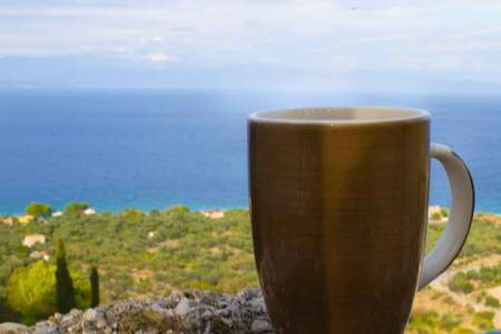 drinking coffee at the morning outside with the autumn sky and beach on the backgroundの写真素材