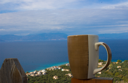 drinking coffee outside and gazing thw forest the sea and the autumn summer skyの写真素材