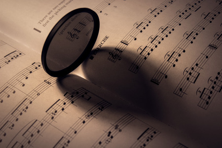purple heart romantic love shape on a piece of music sheet aper under a warm lightの写真素材