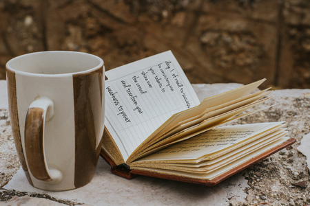 coffee mug and a small open notebook writing about road to successの写真素材