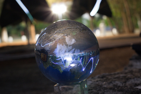 reflection of a night scape throught a crystal ball witha a blured backgroundの写真素材