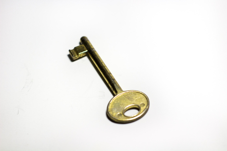 old vintage bronze key isolated on a white backgroundの写真素材