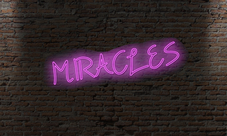 neon letter sign with the word miracles on a brick dark wallの写真素材