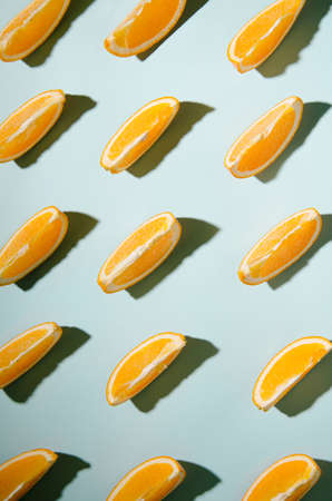 Isolated slices of orange on a light blue background with contrasting shadowsの写真素材