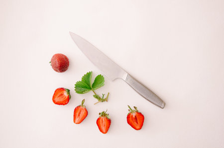 Fresh red strawberry fruit, leaf and knife on white background. Top view, flat lay.の写真素材