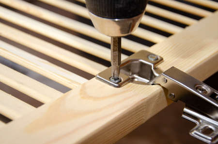 The screwdriver tightens the self-tapping screw of the door hingの写真素材