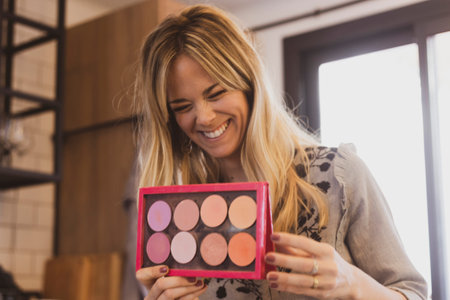 Woman smiling while putting her makeup onの写真素材