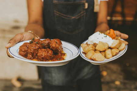 A cook holding two plates of foodの写真素材
