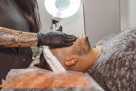 man receiving a facial in a beauty salonの写真素材