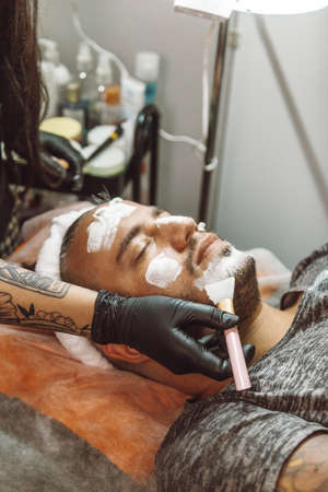 man receiving a facial in a beauty salonの写真素材