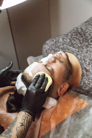 man receiving a facial in a beauty salonの写真素材