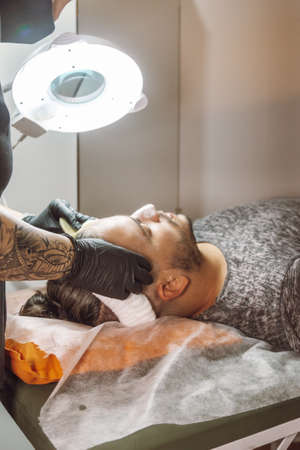 man receiving a facial in a beauty salonの写真素材